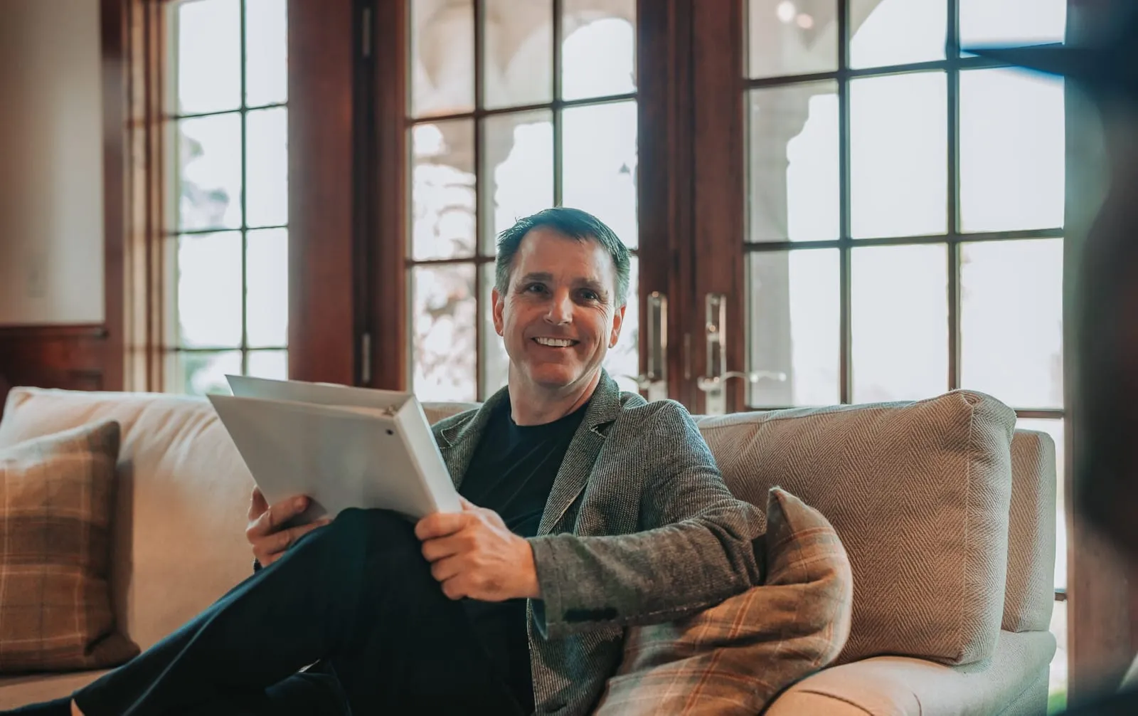 A PIVOT relationship coach seated with a tablet, smiling warmly