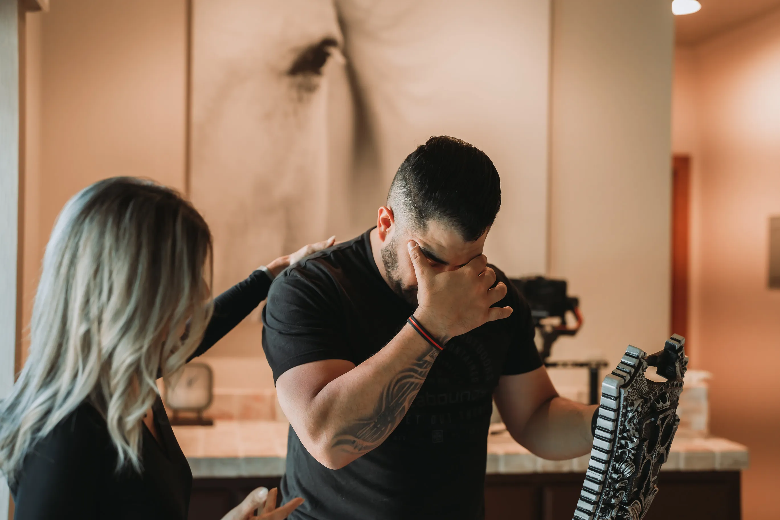 A man in an emotional moment of breakthrough, supported by a PIVOT facilitator