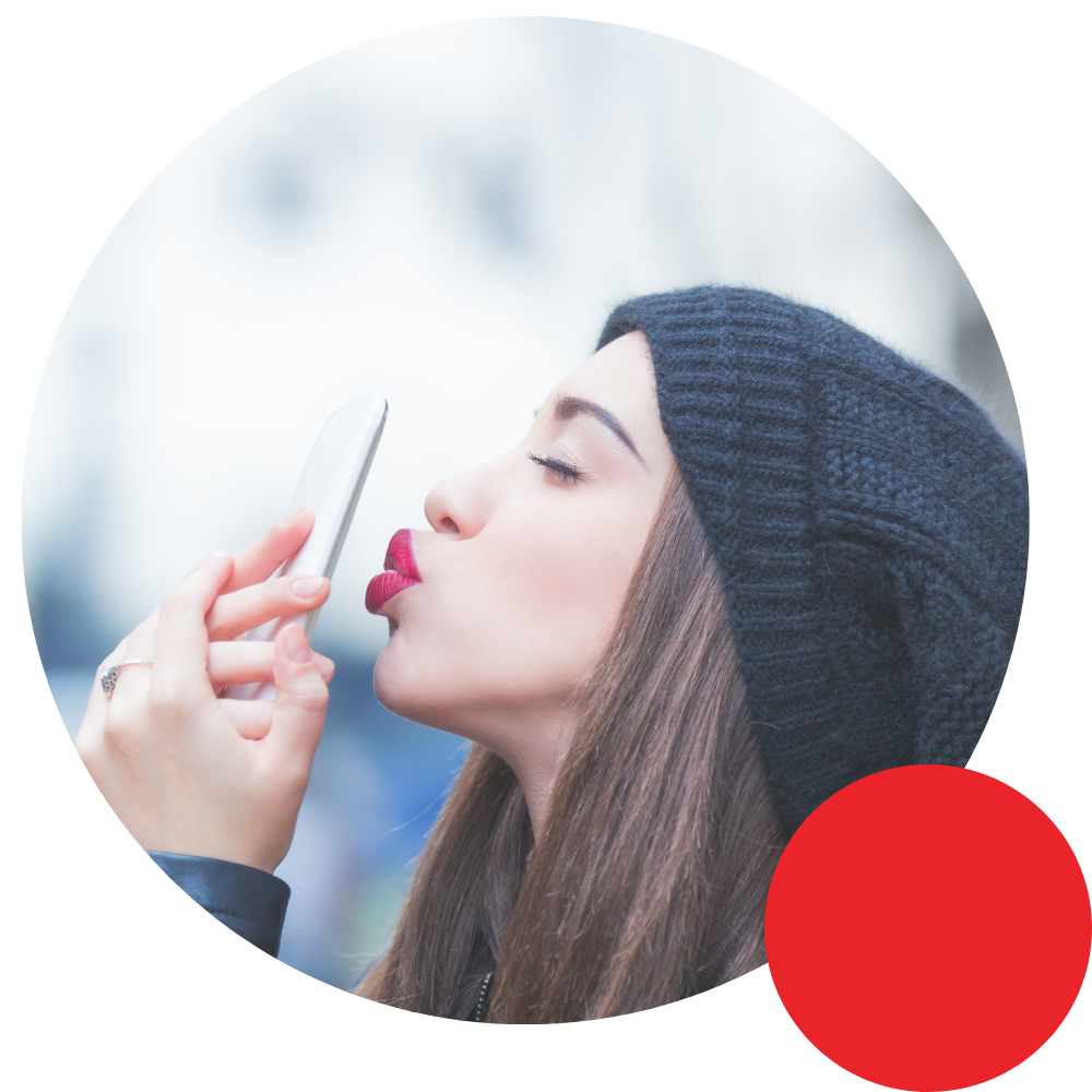 girl with beanie sending a kiss over a phone call attachment love addiciton